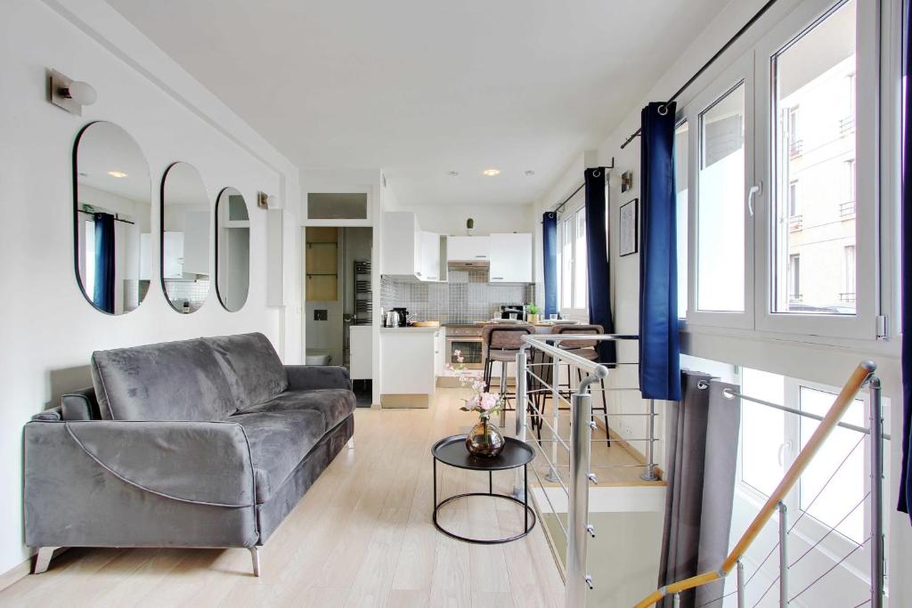 un soggiorno con divano e tavolo di CMG-Cosy Apartment-Parc des Princes-Stade Rolland Garros a Boulogne-Billancourt