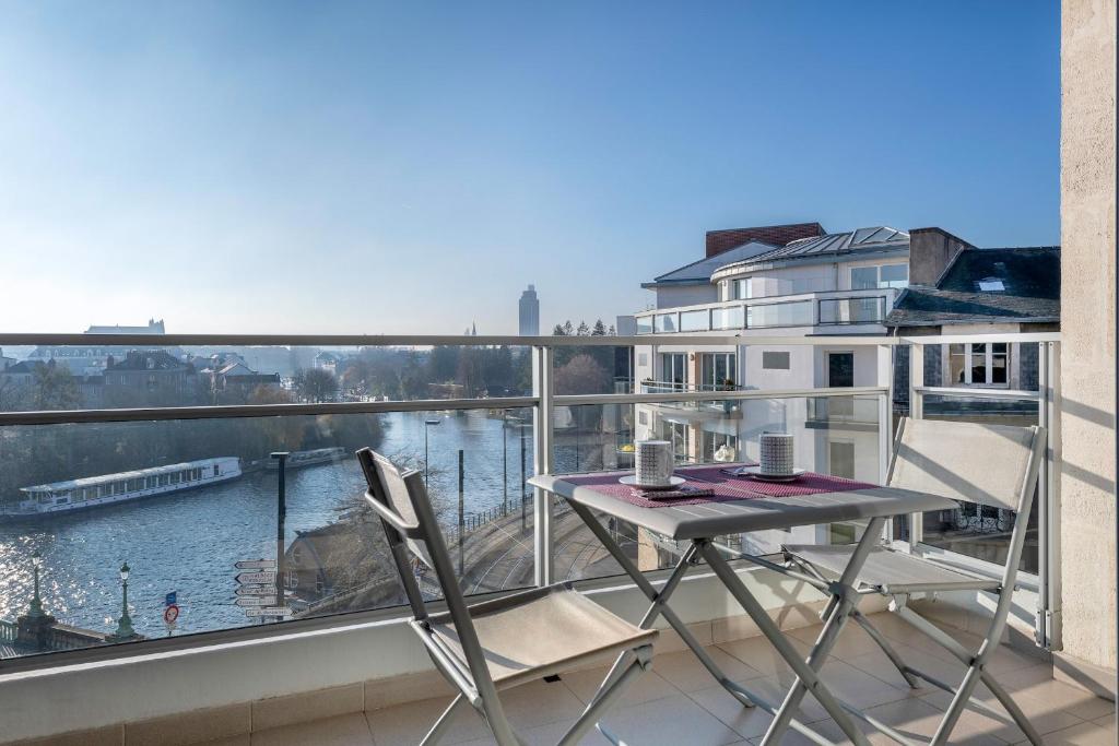 une table et deux chaises sur un balcon avec vue dans l'établissement Appartement avec vue sur l'Erdre pour 4 personnes, à Nantes