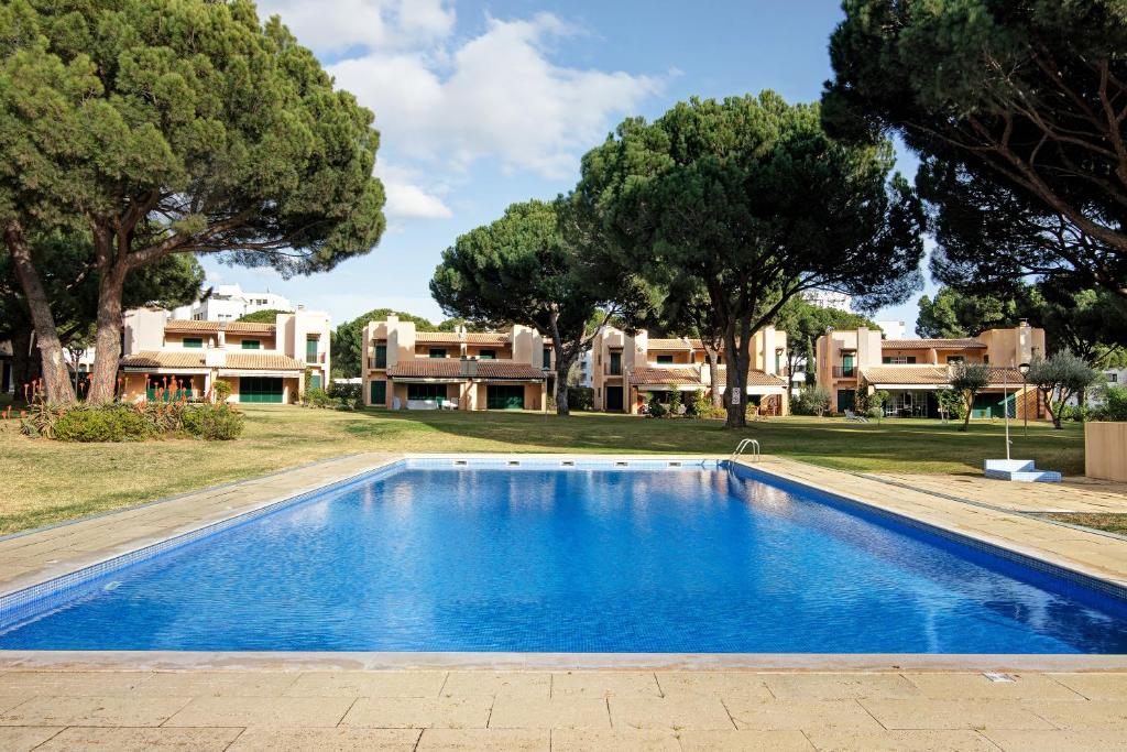 a swimming pool in front of a house at Vilamoura Tenis 58 in Quarteira