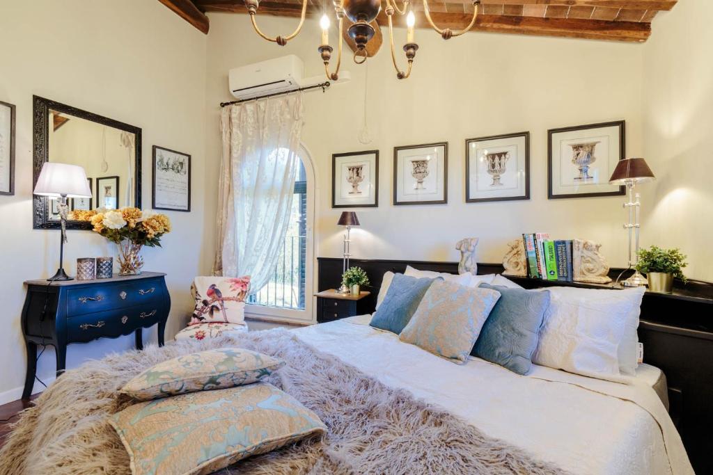 une chambre avec un lit, une table et un miroir dans l'établissement Villa Catia Farmhouse, Three Luxury Bedrooms, a Jacuzzi Pool and a Dream-Like Getaway Experience, à Capannori