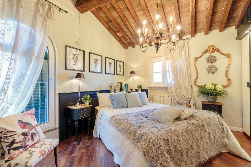 une chambre avec un grand lit et une fenêtre dans l'établissement Villa Catia Farmhouse, Three Luxury Bedrooms, a Jacuzzi Pool and a Dream-Like Getaway Experience, à Capannori