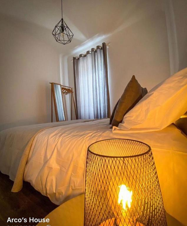 a bedroom with a bed with a lamp next to it at Arco´s Apartment 2 in Ponta Delgada