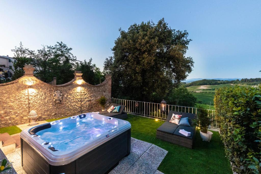 una bañera de hidromasaje en el patio de una casa en Villa Chianti, your Secret 4 Bedrooms Retreat with View over the Vineyards in Marcialla, en Marcialla