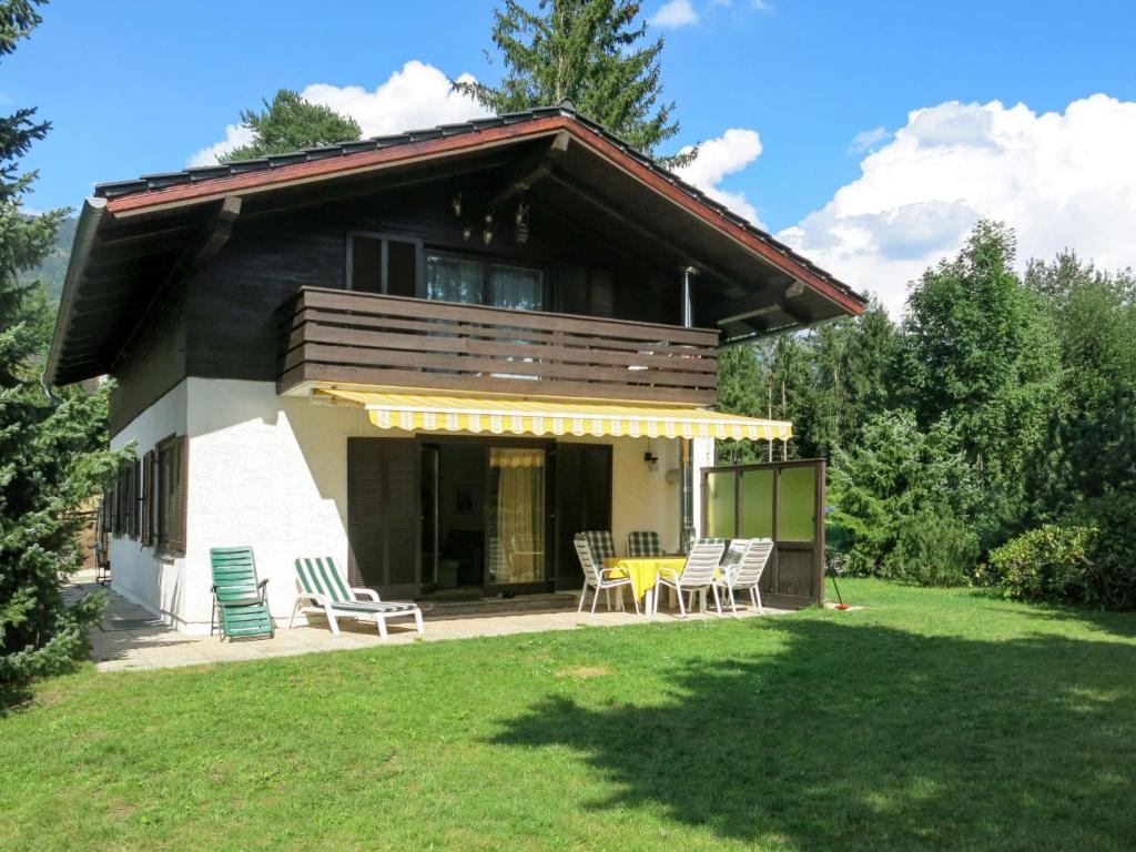 a house with a deck and chairs in the yard at Holiday Home Reier - BOD130 by Interhome in Seeboden