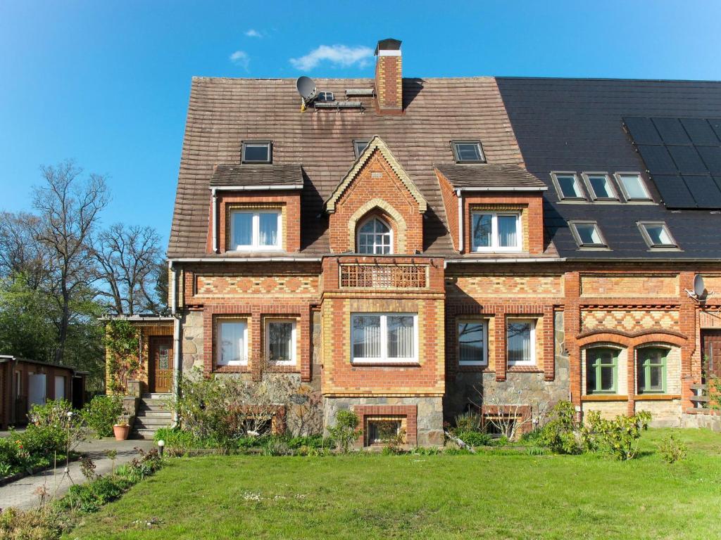 ein großes Backsteinhaus mit Dach in der Unterkunft Apartment Am Park by Interhome in Raben Steinfeld