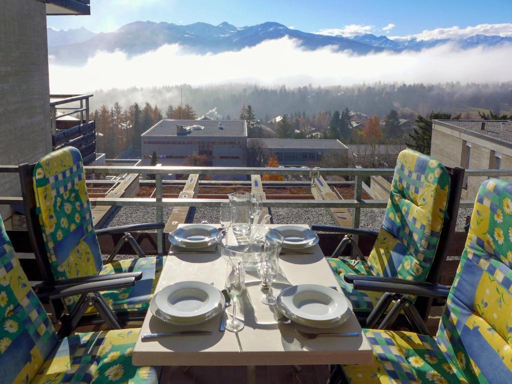 a table and chairs on a balcony with a view at Apartment Jeanne D'Arc Apt- H2-49 by Interhome in Crans-Montana