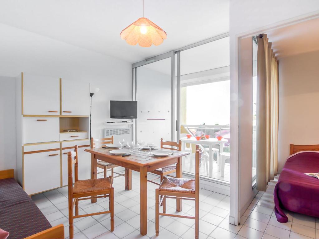 Apartment Voiles d'Or-Gênois-1 by Interhome في لو غراو دو روا: مطبخ وغرفة طعام مع طاولة وكراسي