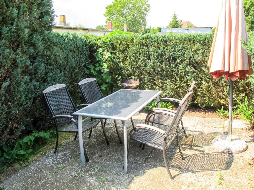 una mesa con 4 sillas y una sombrilla en Holiday Home Am See II by Interhome, en Verchen