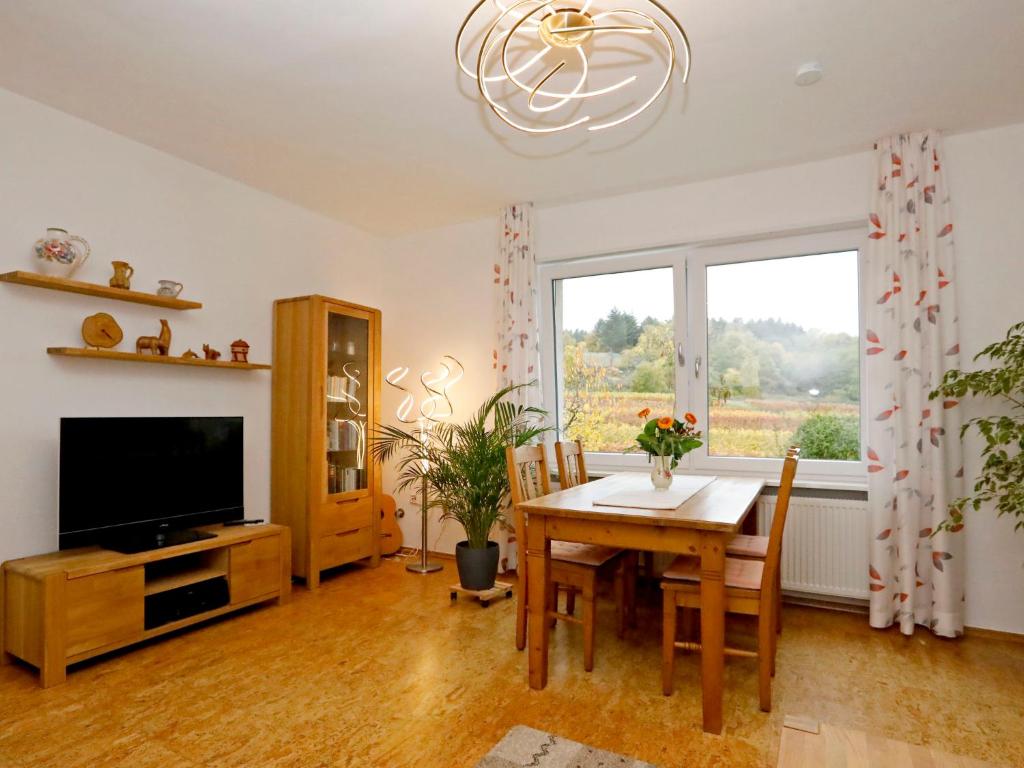 Sala de estar con mesa de comedor y TV en Apartment Am Weinberg by Interhome, en Bad Dürkheim