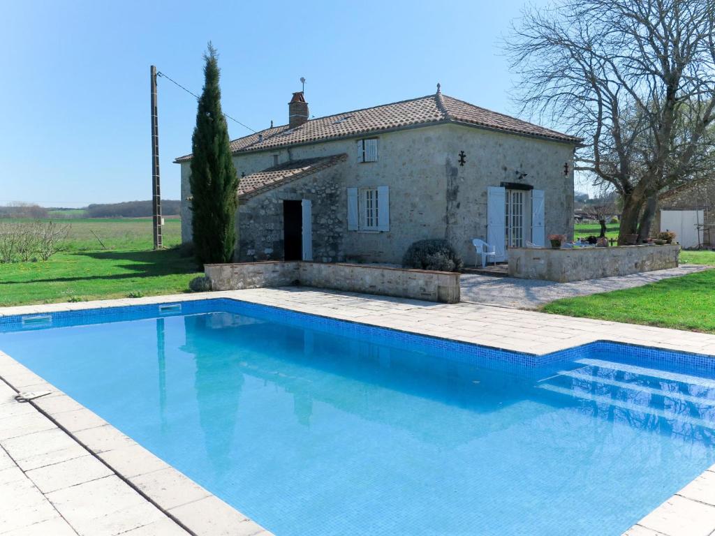eine Villa mit einem Pool vor einem Haus in der Unterkunft Holiday Home Bouvignou - PDG301 by Interhome in Penne-dʼAgenais