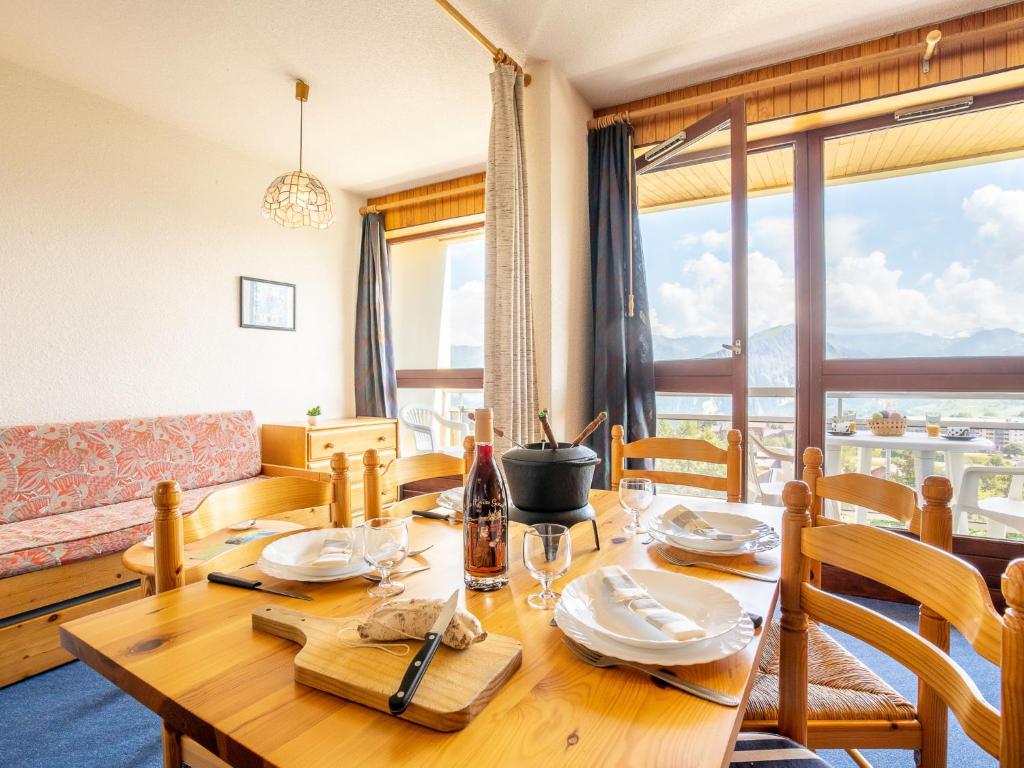 a dining room with a table and a couch at Apartment Cote Louve by Interhome in La Toussuire