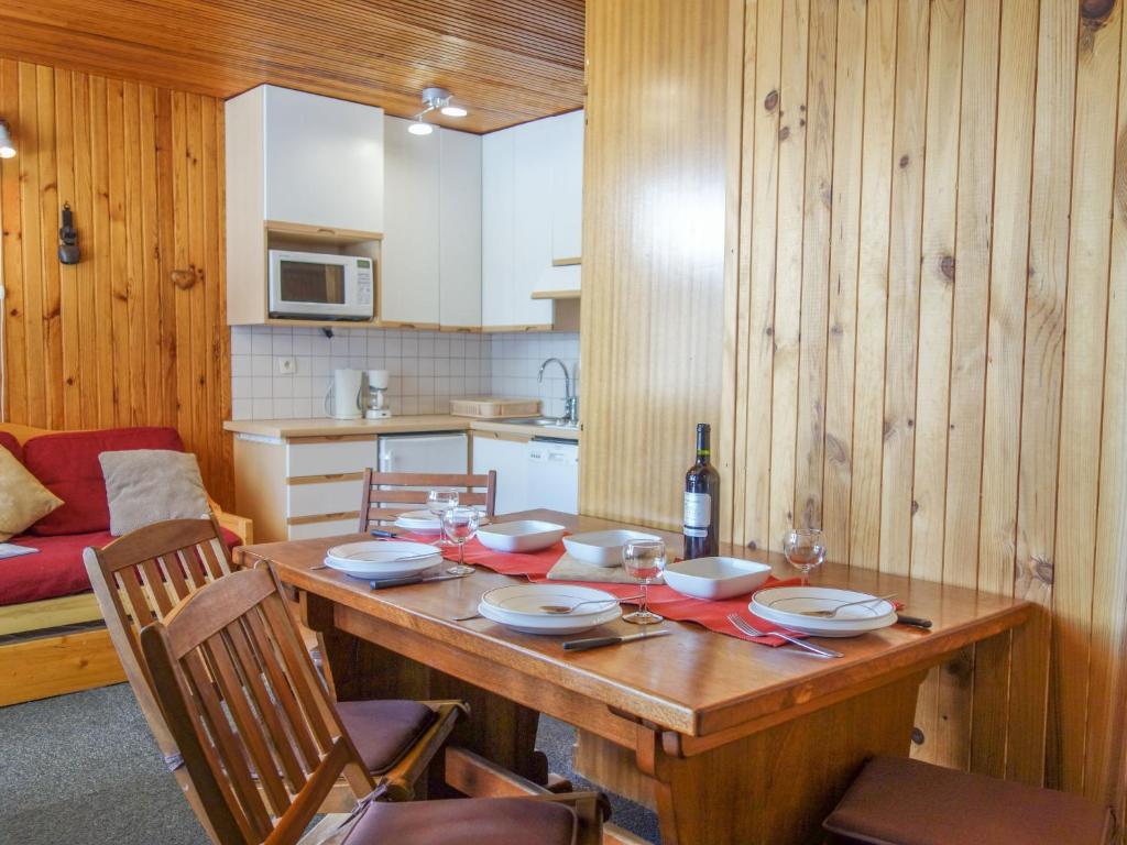 - une cuisine avec une table en bois, des assiettes et des verres à vin dans l'établissement Studio Le 2100 A et B - Lavachet-8 by Interhome, à Tignes