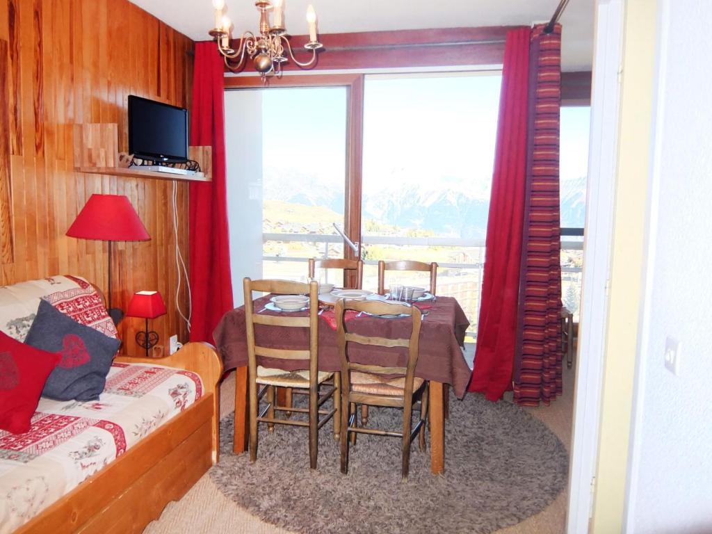 Pokój ze stołem, krzesłami i oknem w obiekcie Apartment Bellard-2 by Interhome w mieście La Toussuire