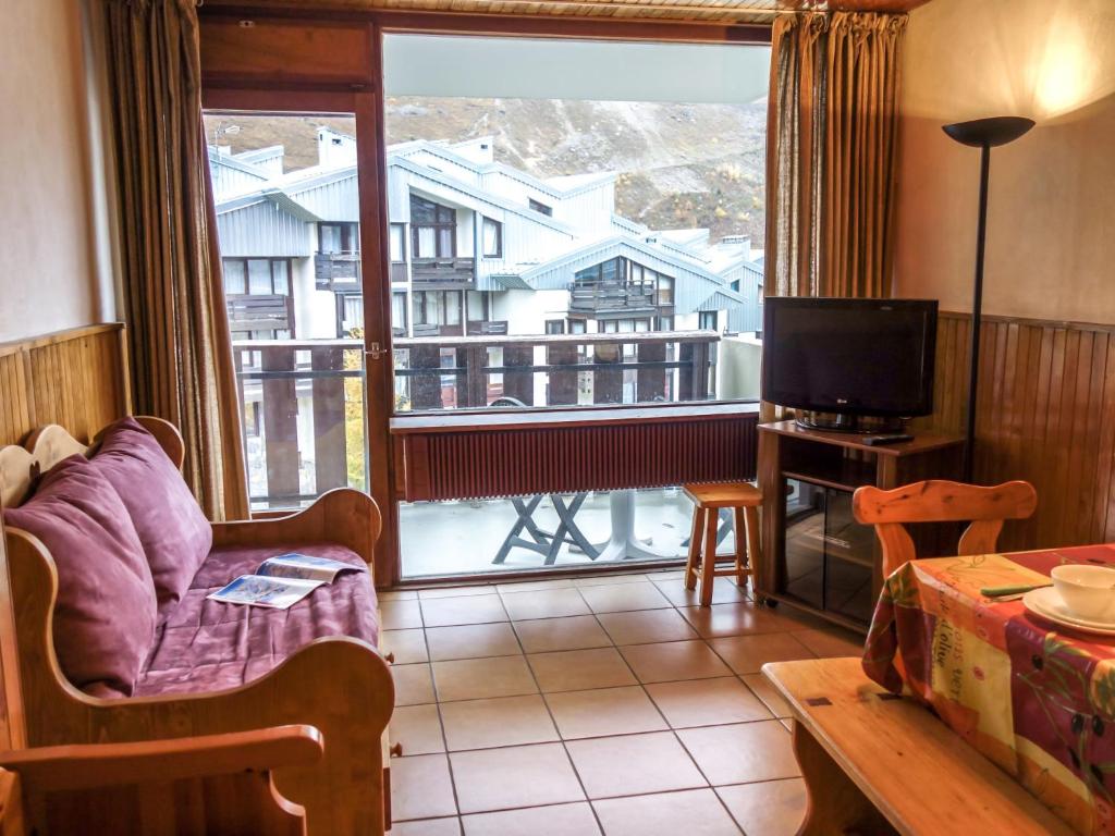 a living room with a couch and a large window at Apartment Le 2100 A et B-7 by Interhome in Tignes