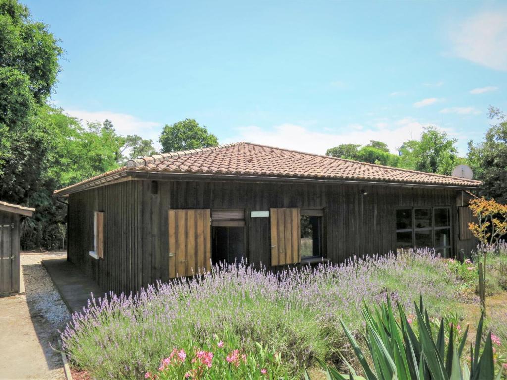 una casa de madera con un campo de flores púrpuras en Holiday Home Les Bains Douche - SUL180 by Interhome, en Soulac-sur-Mer