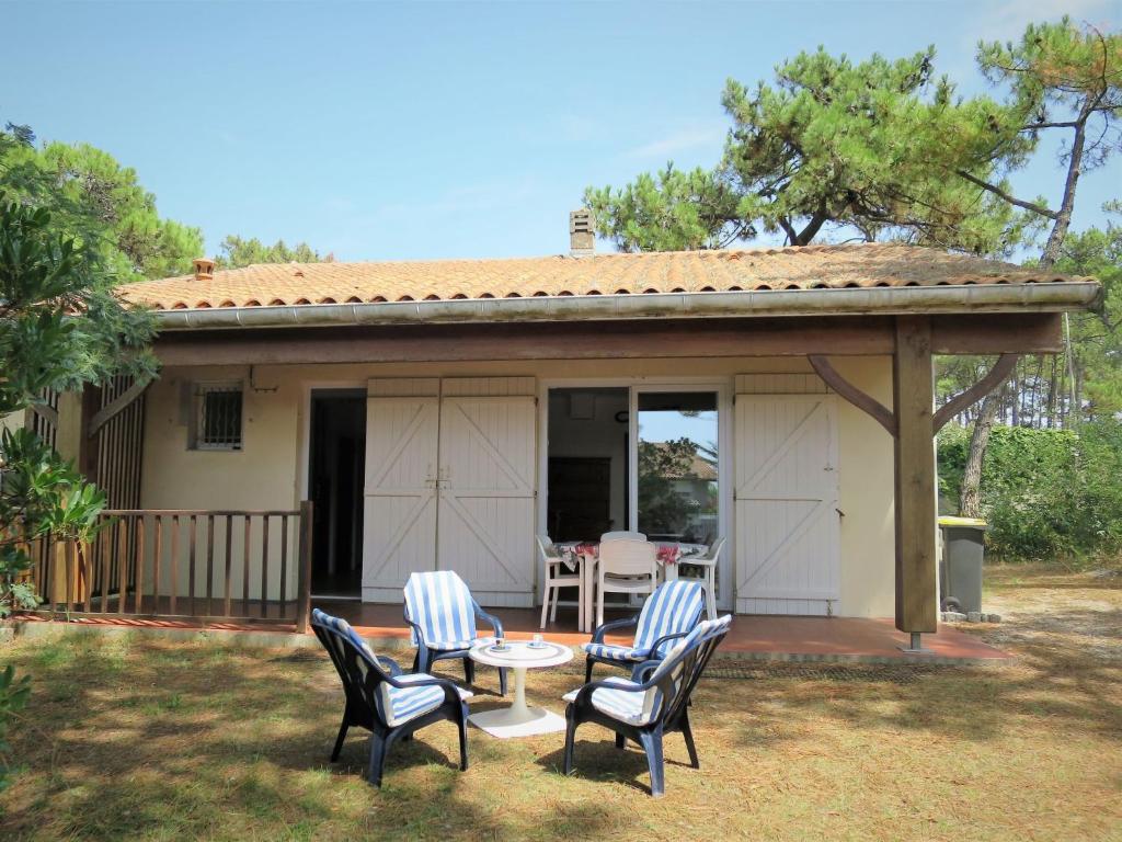 um pátio com cadeiras e uma mesa em frente a uma casa em Holiday Home Anne Marie - LCA195 by Interhome em Lacanau-Océan