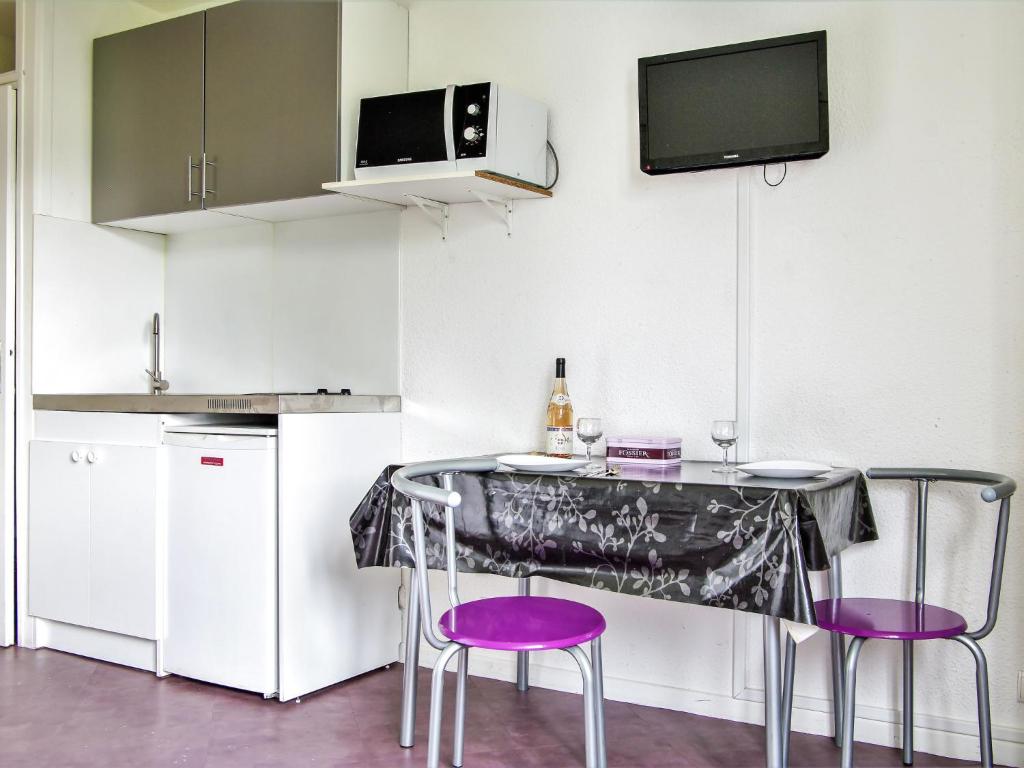 シャモニー・モンブランにあるStudio Arve 1 et 2-3 by Interhomeのキッチン(紫色の椅子、テーブル、テレビ付)