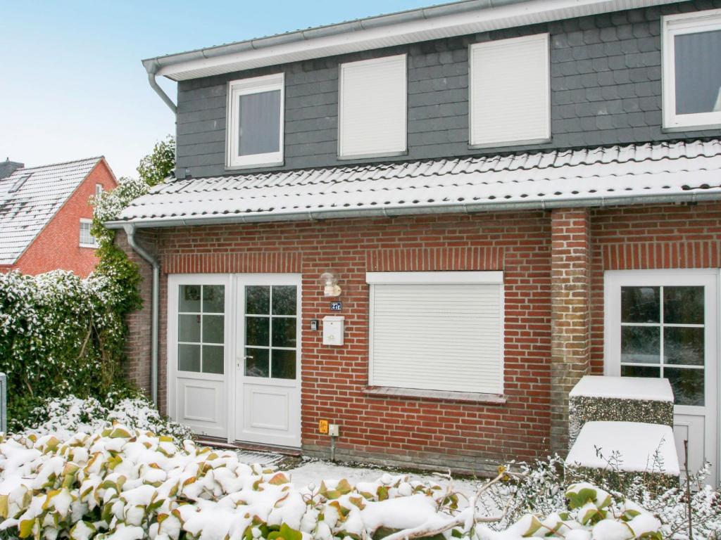 ein Backsteinhaus mit weißen Türen im Schnee in der Unterkunft Apartment Dehne-1 by Interhome in Norddeich