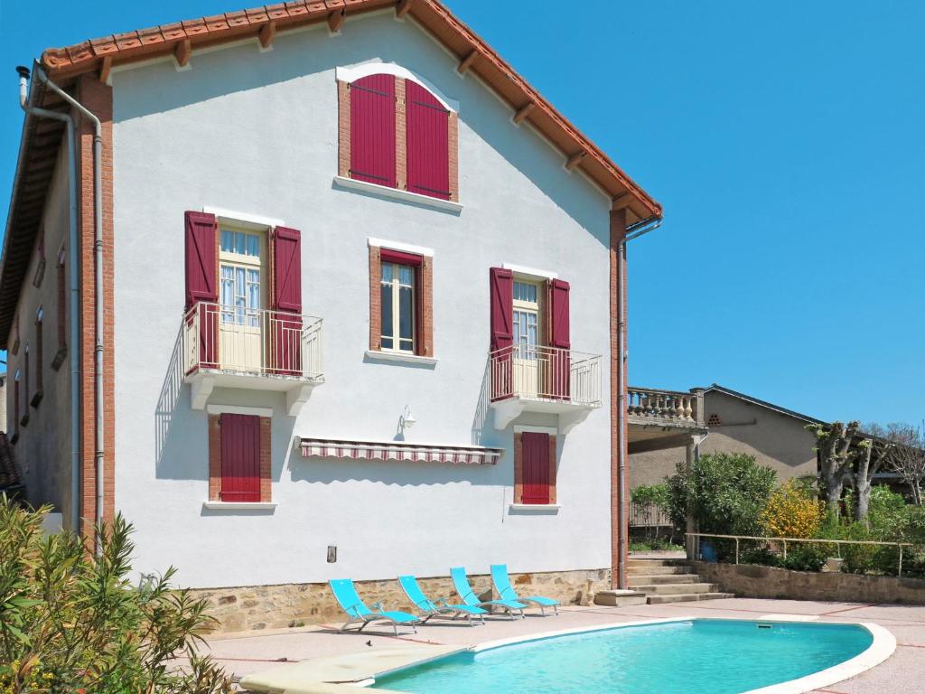 a house with red shuttered windows and a swimming pool at Holiday Home Lacapelle - LPR100 by Interhome in Lacapelle-Ségalar