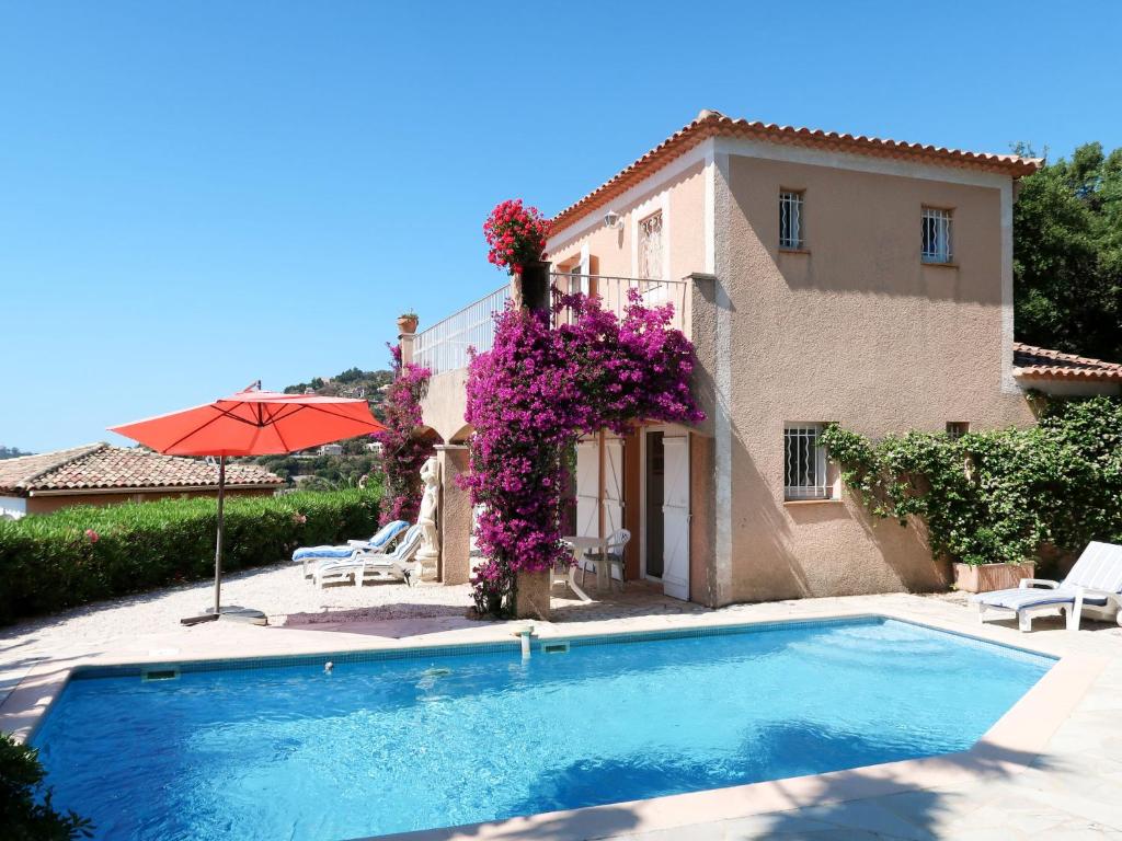 a villa with a swimming pool in front of a house at Holiday Home Yalou by Interhome in Cavalaire-sur-Mer