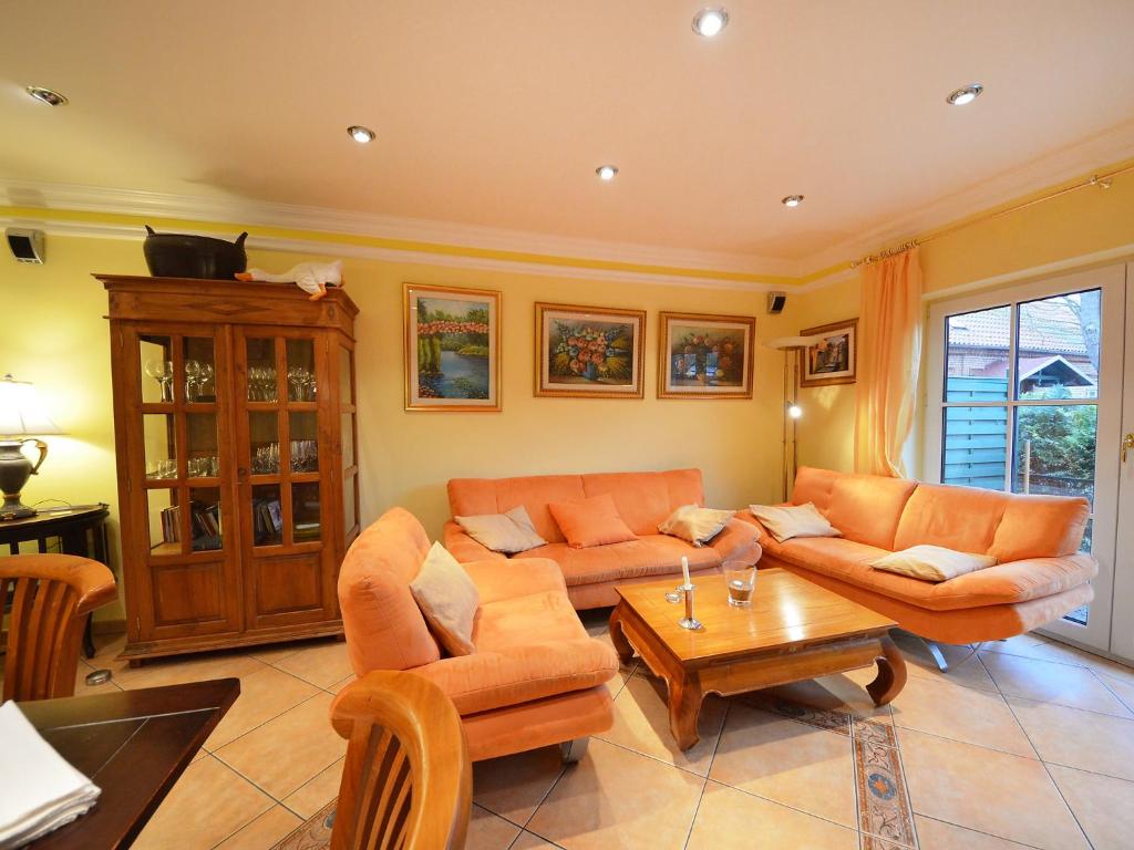 - un salon avec des canapés orange et une table basse dans l'établissement Holiday Home Sanddorn by Interhome, à Groß Zicker