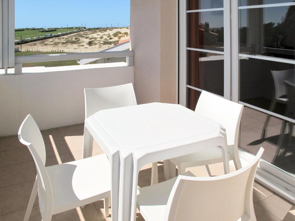 a white table and chairs on a balcony with a view of the beach at Apartment Résidence Belle Dune - BPL332 by Interhome in Biscarrosse-Plage