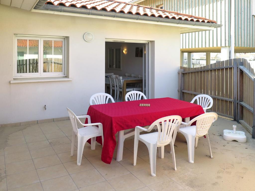 a table and chairs with a red table cloth on a patio at Holiday Home Résidence Plage Océane - BPL340 by Interhome in Biscarrosse-Plage