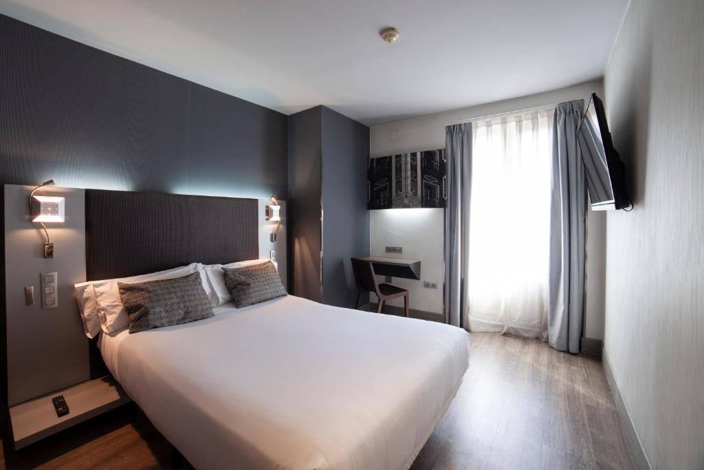 a bedroom with a large white bed and a window at Petit Palace Plaza España in Madrid