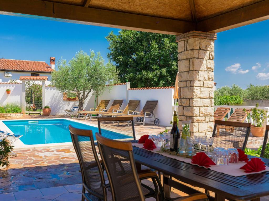 a patio with a table and a swimming pool at Holiday Home Ksenija-2 by Interhome in Čepljani
