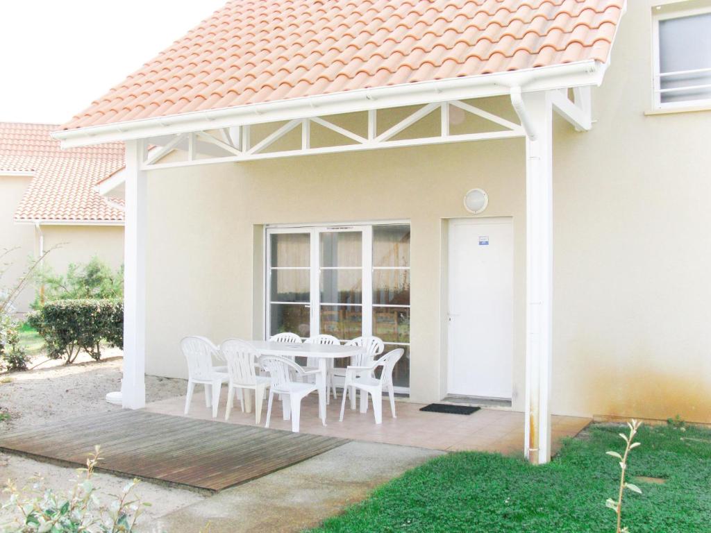a white pergola on a house with a table and chairs at Holiday Home Résidence Dune Blanche - Océan1 - BPL321 by Interhome in Biscarrosse-Plage