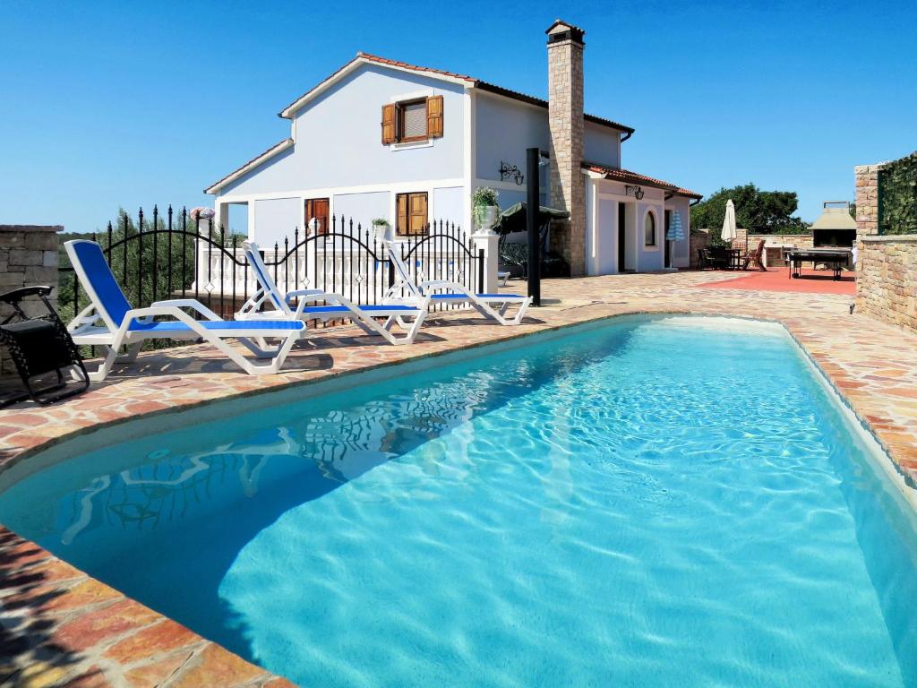 una piscina con due sedie e una casa di Holiday Home Stella by Interhome a Labin