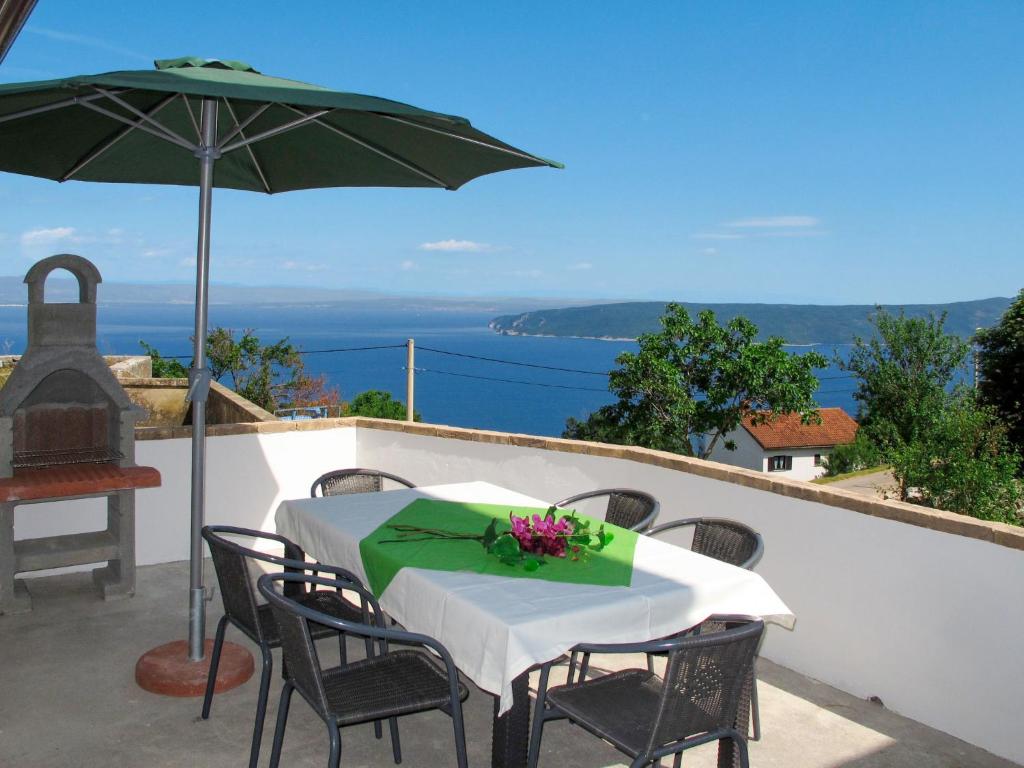 a table and chairs with an umbrella on a balcony at Holiday Home Matea - MOD207 by Interhome in Martina