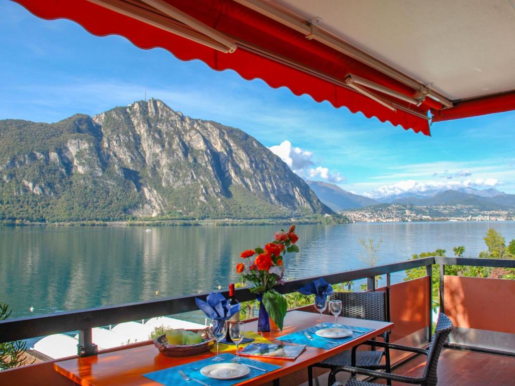 ビッソーネにあるApartment Lago di Lugano-3 by Interhomeの山の景色を望むバルコニー(テーブル付)