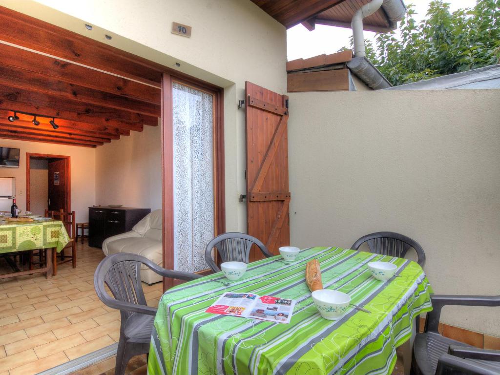 a table with a green and white table cloth at Holiday Home Sicard-5 by Interhome in Mimizan-Plage