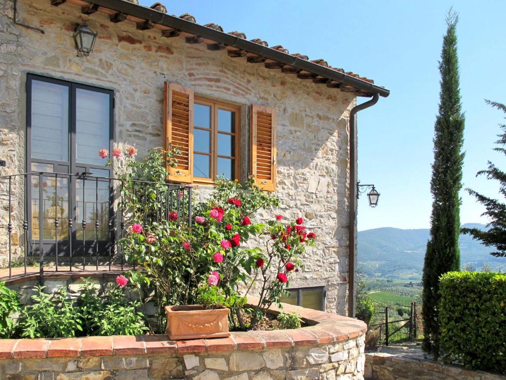 Casa de piedra con ventana y rosas rojas en Holiday Home San Rocco-1 by Interhome, en Greve in Chianti
