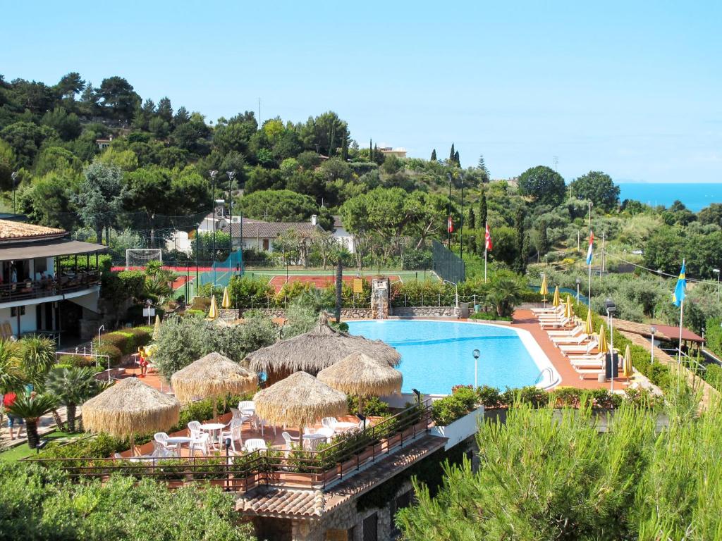 a resort with a swimming pool and straw umbrellas at Apartment Costa di Kair ed Din-3 by Interhome in Sperlonga