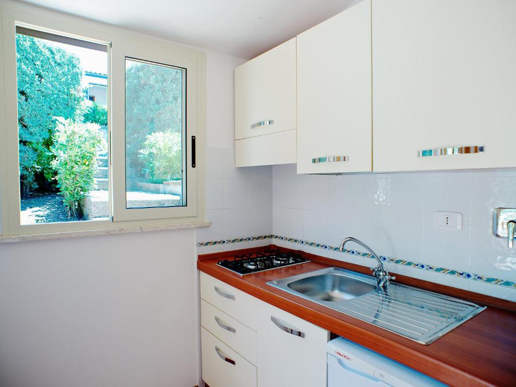 a kitchen with white cabinets and a sink and a window at Apartment Costa di Kair ed Din-3 by Interhome in Sperlonga