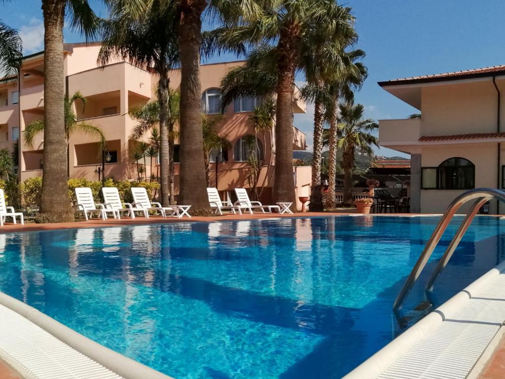 una piscina frente a un hotel con palmeras en Apartment Laura-1 by Interhome, en Castellammare di Velia