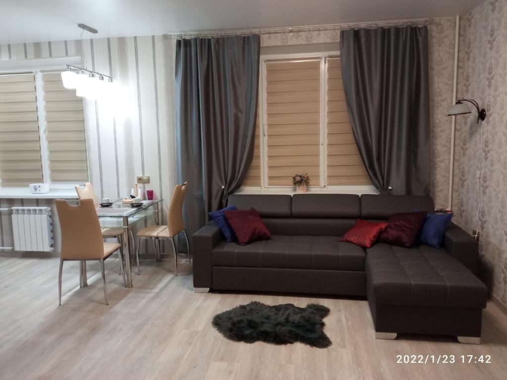 a living room with a black couch and a table at Vanalinna Apartment in Narva