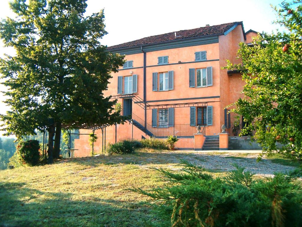 ein großes Backsteingebäude mit Bäumen davor in der Unterkunft Apartment Cascina Villa - AST231 by Interhome in Rocca D'Arazzo