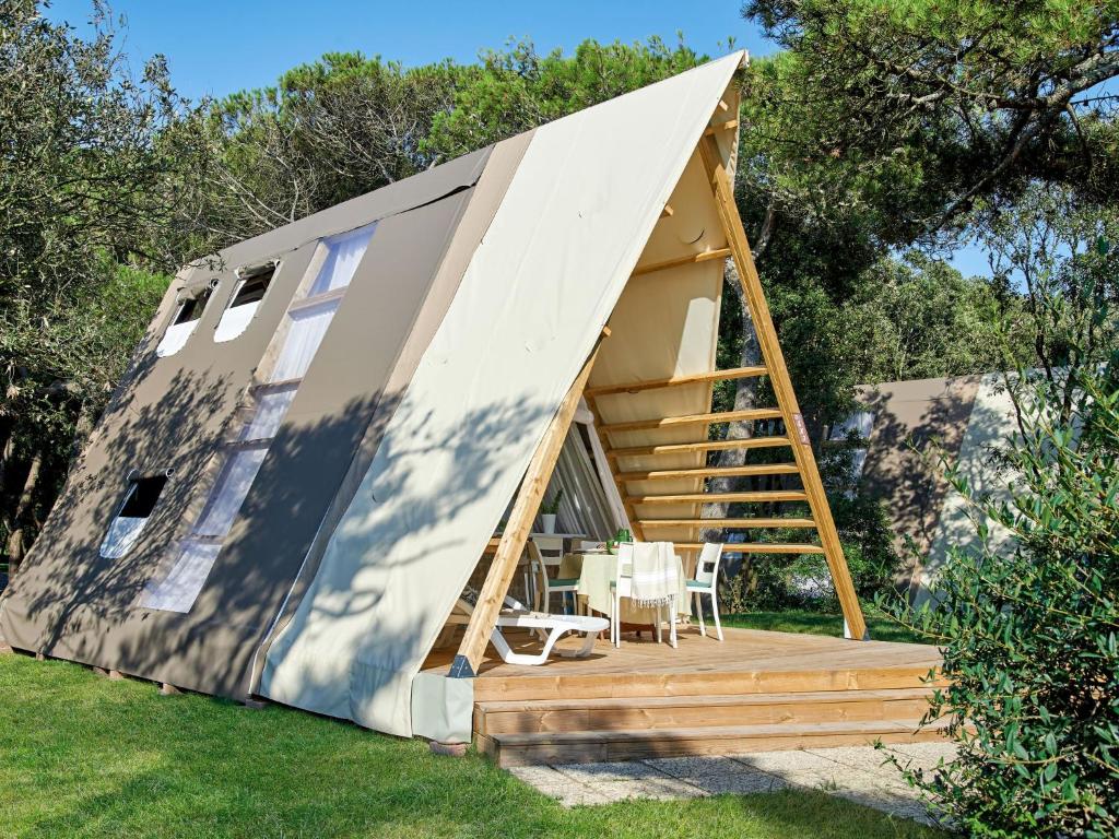 a tiny house with a staircase in a yard at Holiday Home Luxury Tent by Interhome in Baia Domizia