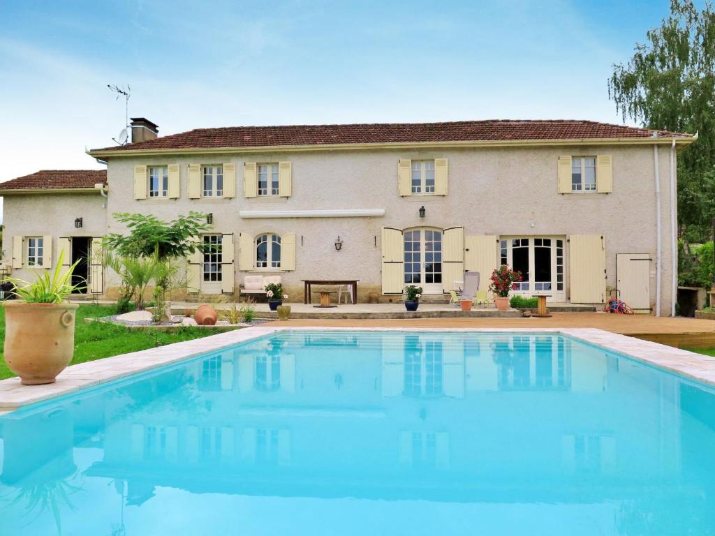 a large house with a swimming pool in front of it at Holiday Home Aucéloun - NAS100 by Interhome in Nassiet
