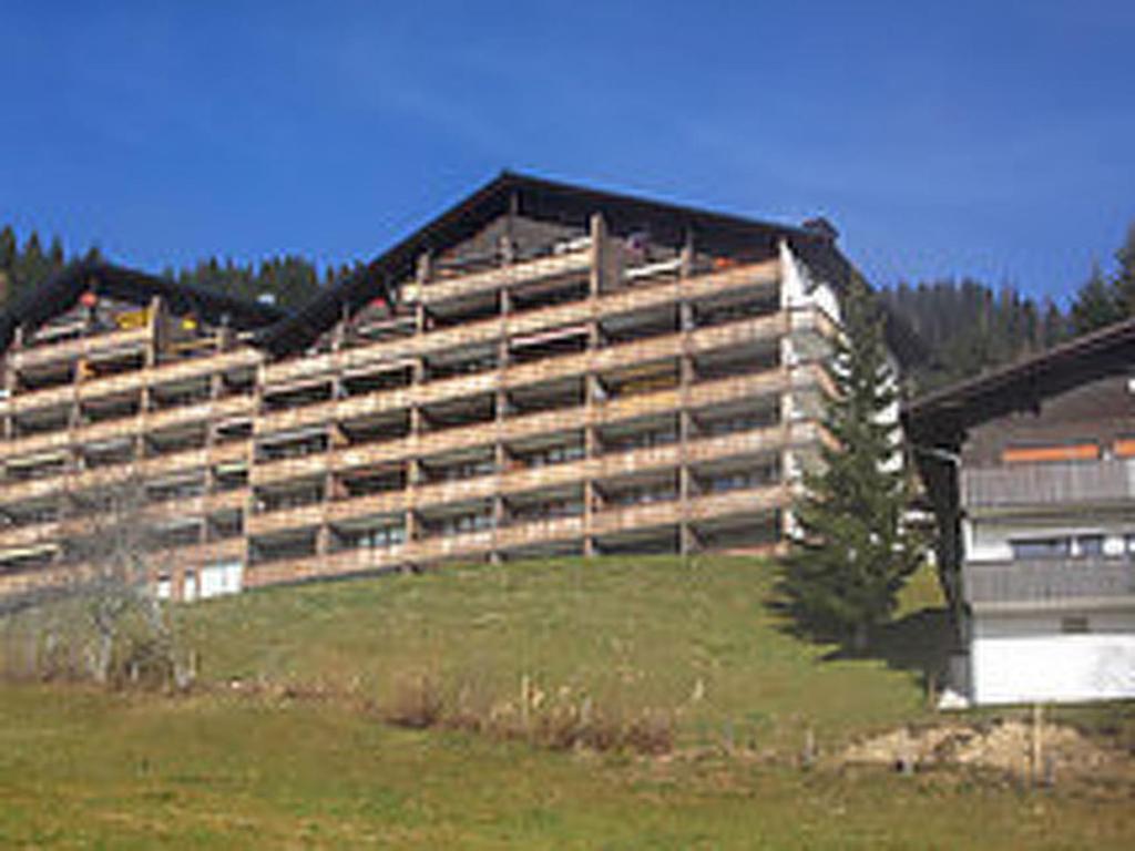 ein großes Gebäude auf einem Hügel auf einem Feld in der Unterkunft Apartment Sonnenhang by Interhome in Grünholzer