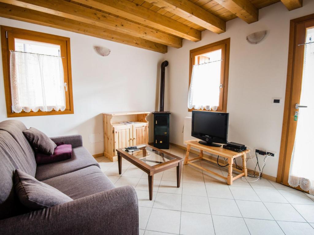 ein Wohnzimmer mit einem Sofa und einem TV in der Unterkunft Holiday Home Albergo Diffuso - Cjasa Paron Cilli by Interhome in Barcis