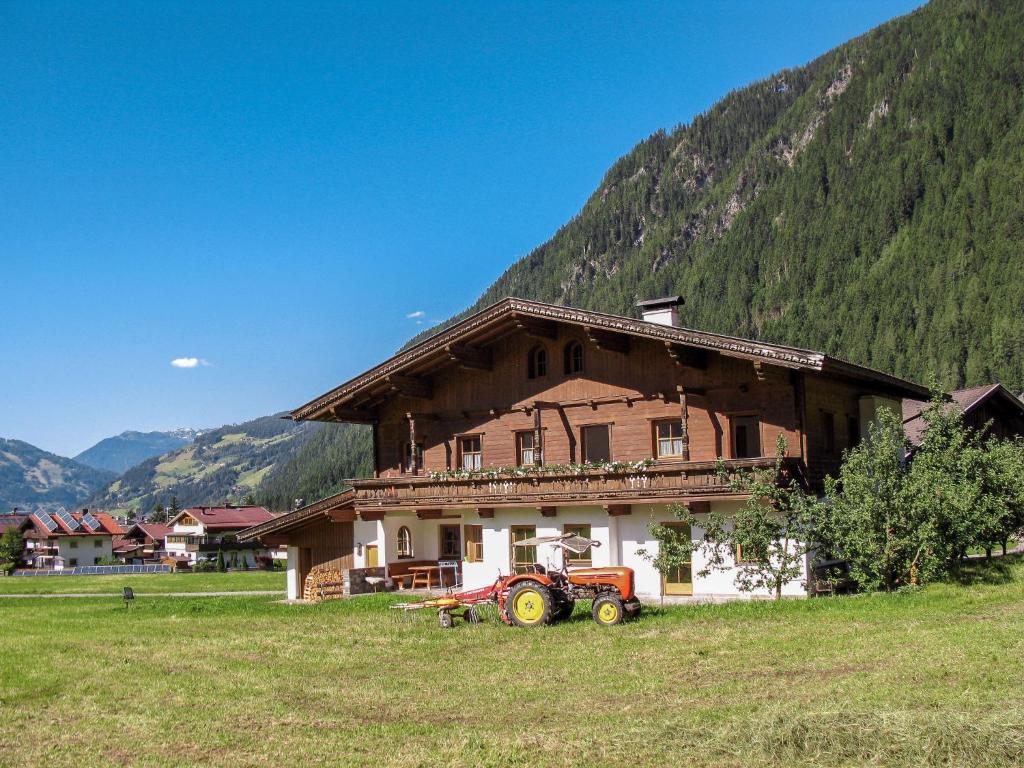 ciągnik zaparkowany przed domem na polu w obiekcie Apartment Gredler-2 by Interhome w Mayrhofen