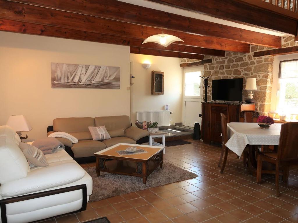 ein Wohnzimmer mit einem Sofa und einem Tisch in der Unterkunft Holiday Home Le Gite des Oyats by Interhome in Belz