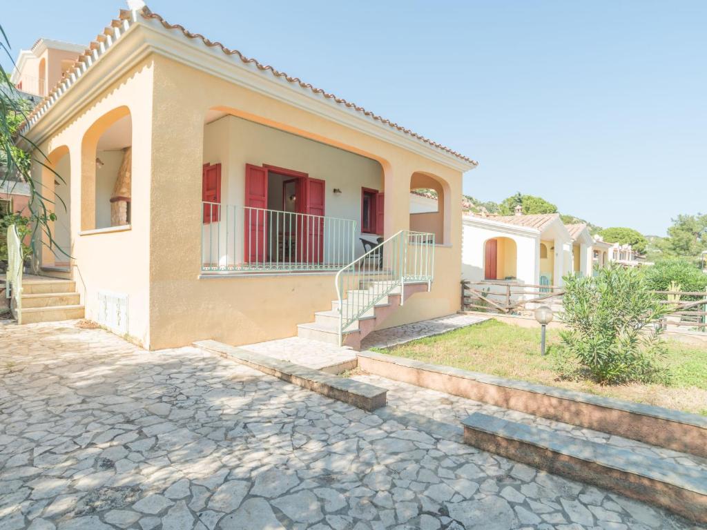 a house with a stone driveway in front of it at Holiday Home Case Greche Basse - REI235 by Interhome in Costa Rei