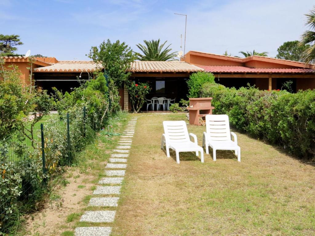 two white chairs sitting in the yard of a house at Holiday Home Rei Mare Fronte Marina - REI205 by Interhome in Monte Nai