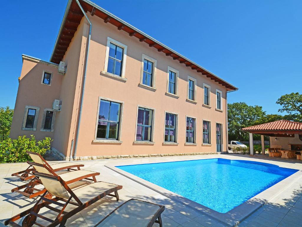 a villa with a swimming pool in front of a house at Villa Old School House by Interhome in Bašići