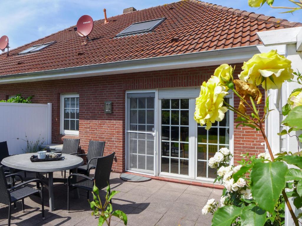 a patio with a table and chairs in front of a house at Holiday Home Adda by Interhome in Neßmersiel